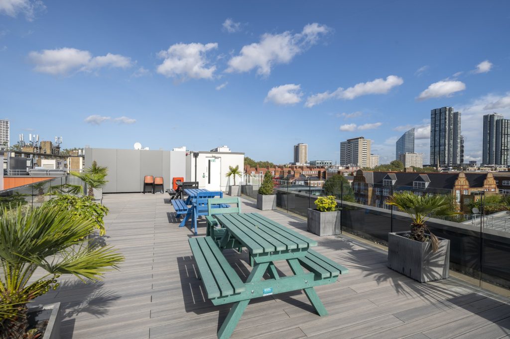 Newly refurbished office space in The Poppy Building, located in Brewhouse Yard, London's Tech Hub, featuring floor-to-ceiling windows and a communal roof terrace.